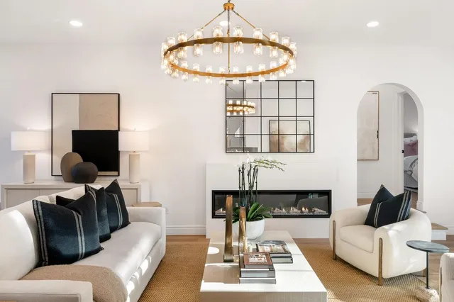 a kitchen with stainless steel appliances kitchen island granite countertop a refrigerator a sink dishwasher a dining table and chairs with wooden floor