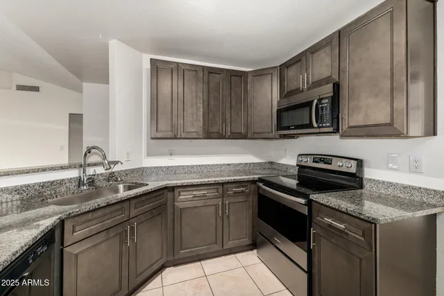 a kitchen with stainless steel appliances granite countertop a sink stove and microwave