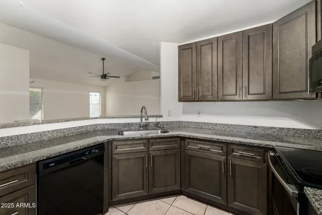 a kitchen with stainless steel appliances granite countertop a sink stove and cabinets