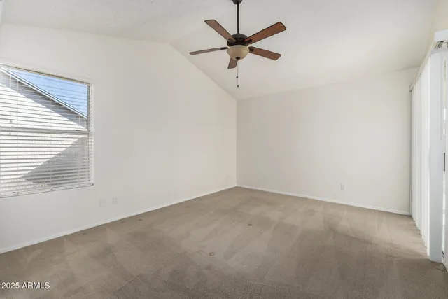 an empty room with a window and a fan