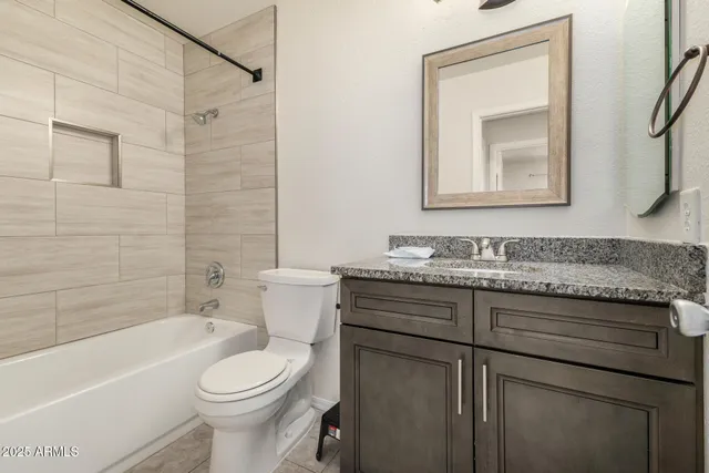 a bathroom with a granite countertop toilet a sink and bathtub