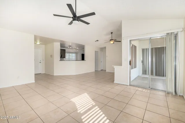 a view of a big room with wooden floor and a chandelier fan