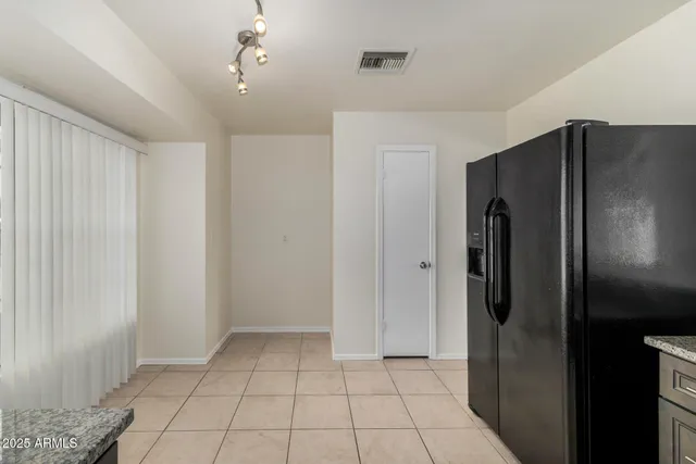 a view of a refrigerator in kitchen and white cabinets