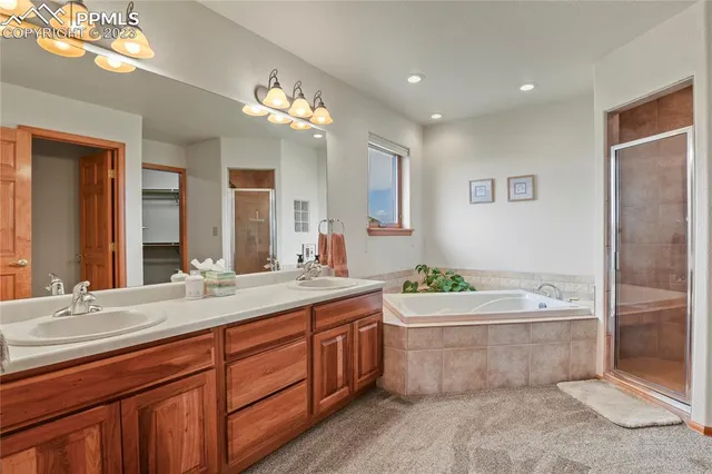 a bathroom with a sink double vanity granite tub and a mirror