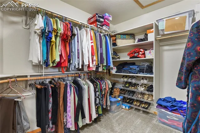 a view of walk in closet with clothes