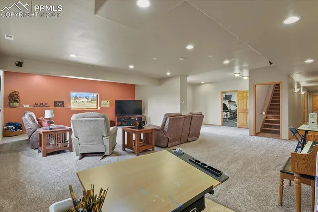 a living room with furniture a flat screen tv and kitchen view