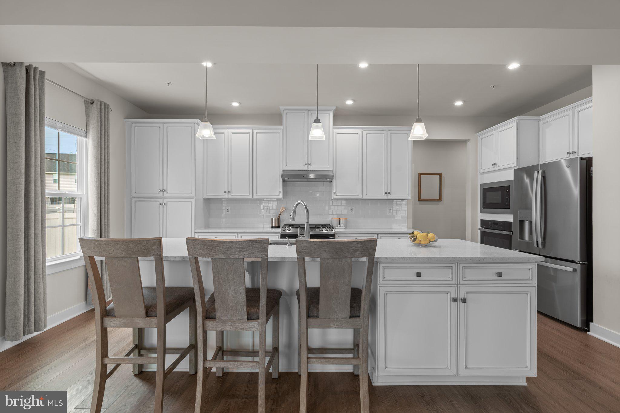 3150 Dodder Way Odenton, MD 21113 - Photo 11 of 83 a kitchen with stainless steel appliances kitchen island granite countertop a dining table chairs refrigerator and sink
