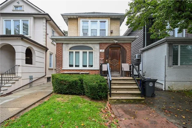 a front view of a house with a garden