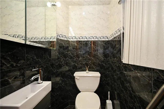 a bathroom with a toilet a sink and mirror