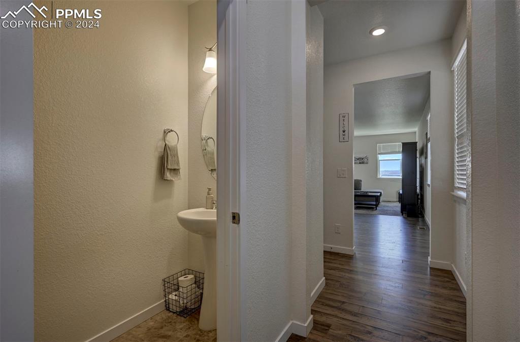 45780 Silverdrop Avenue Bennett, CO 80102 - Photo 7 of 43 a view of a hallway with wooden floor and a bathroom