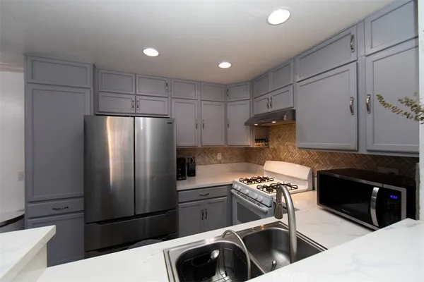 a kitchen with stainless steel appliances granite countertop a refrigerator and a stove