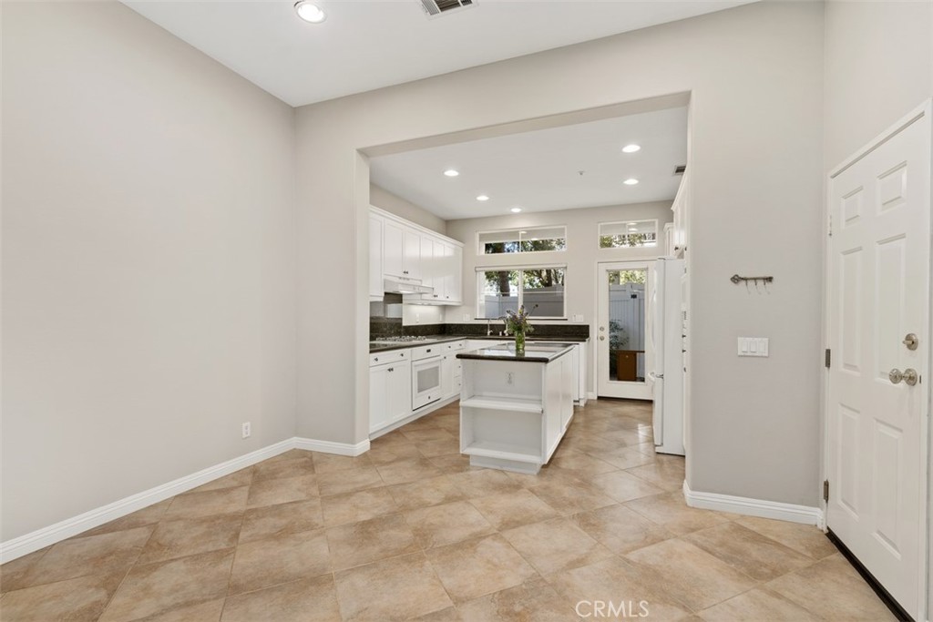61 Burlingame Irvine, CA 92602 - Photo 5 of 13 a large white kitchen with a stove a sink dishwasher and a refrigerator with wooden floor