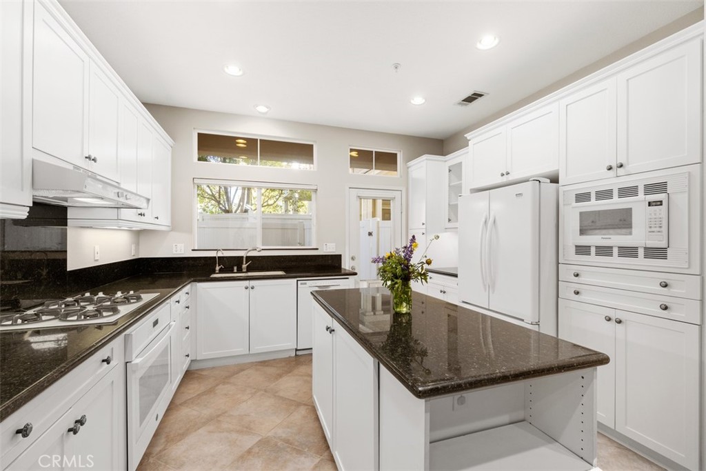 61 Burlingame Irvine, CA 92602 - Photo 6 of 13 a kitchen with stainless steel appliances granite countertop a sink a stove and a refrigerator