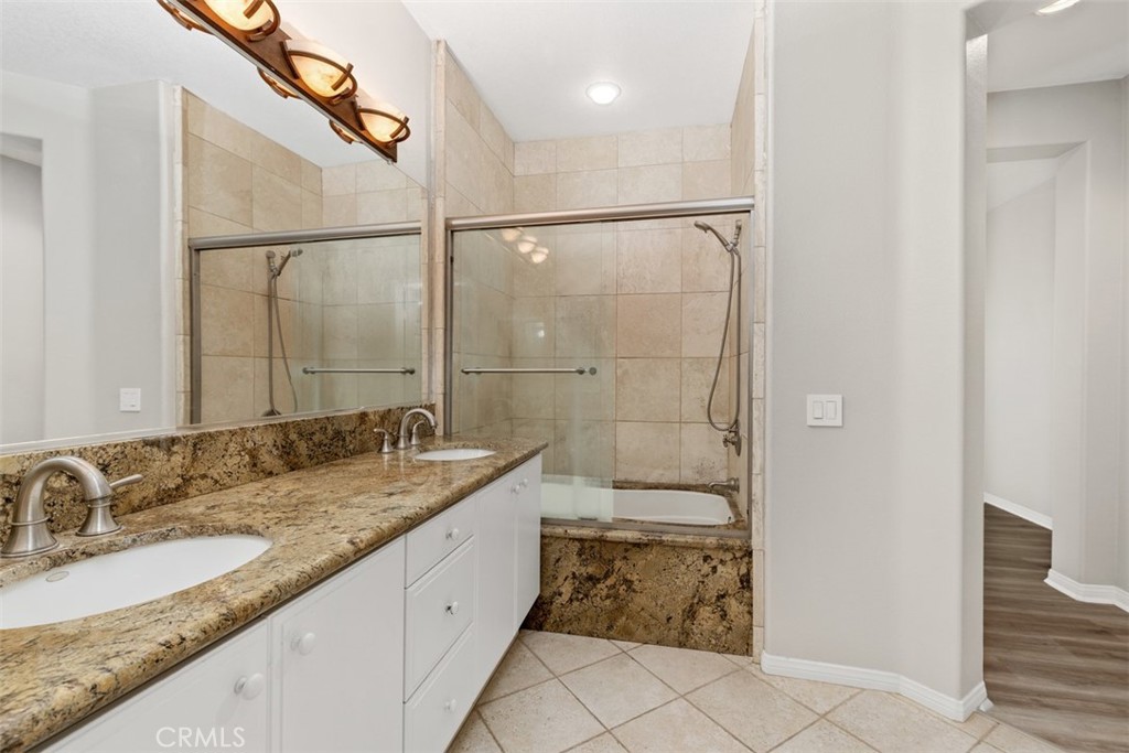 61 Burlingame Irvine, CA 92602 - Photo 10 of 13 a bathroom with a granite countertop sink a mirror and a shower