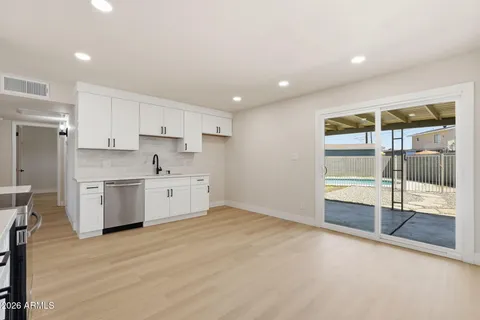 a view of a kitchen with wooden floor and electronic appliances