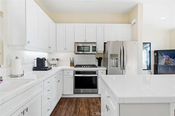 a kitchen with cabinets stainless steel appliances and sink