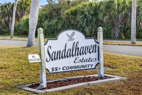 a view of a sign board with large trees