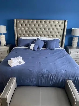 a bedroom with a bed and a lamp on dresser