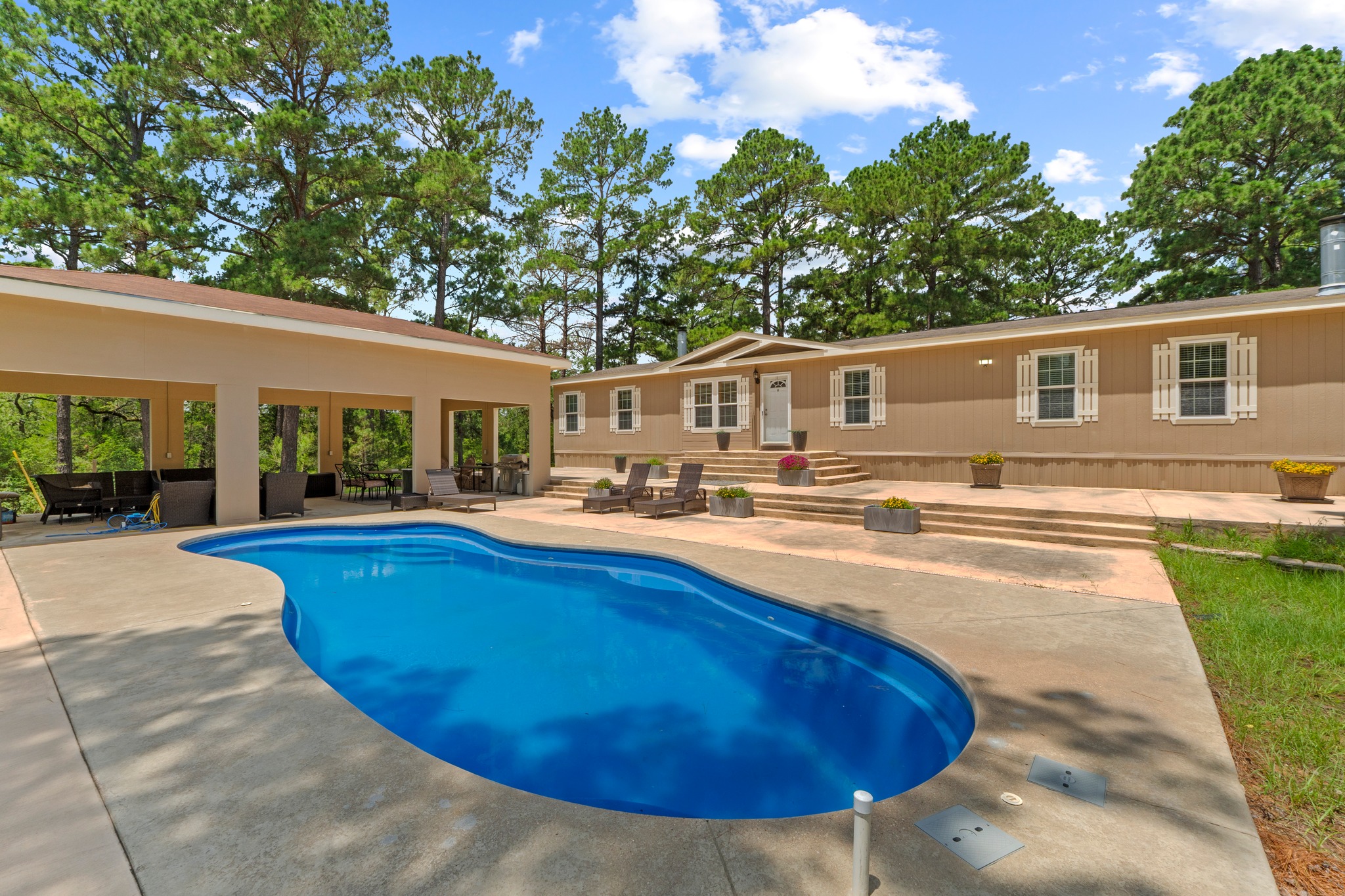 438 Kellar Road Smithville, TX 78957 - Photo 2 of 30 An inviting outdoor oasis with a sparkling pool and generous patio space for entertainment.