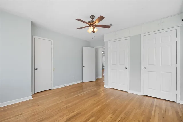 a view of a livingroom with a ceiling fan & a window