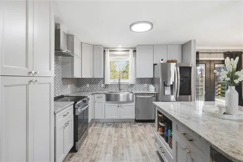 a kitchen with white cabinets and stainless steel appliances