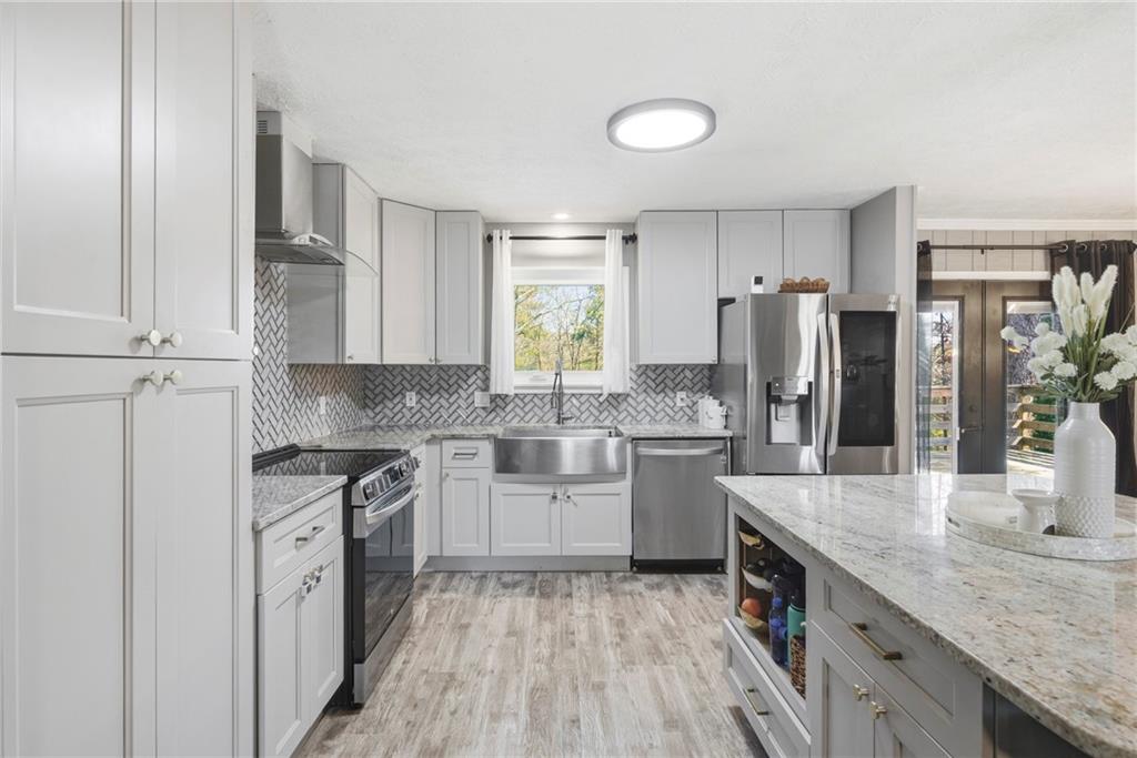 2470 Northbrook Road Snellville, GA 30039 - Photo 10 of 29 a kitchen with white cabinets and stainless steel appliances