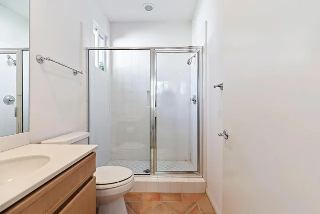 a bathroom with a granite countertop sink toilet and shower