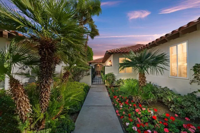 a front view of a house with a yard and potted plants