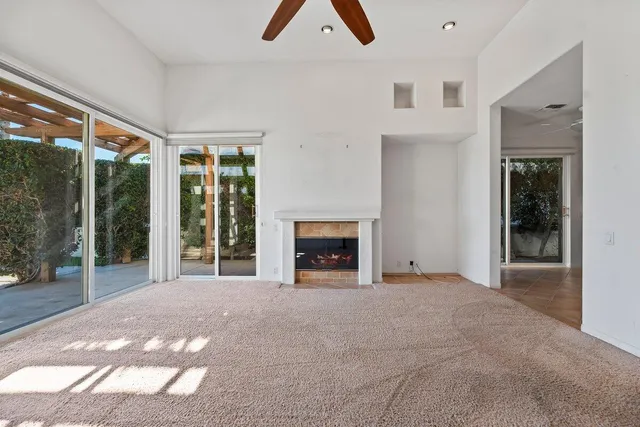 a view of an empty room with a fireplace and a window