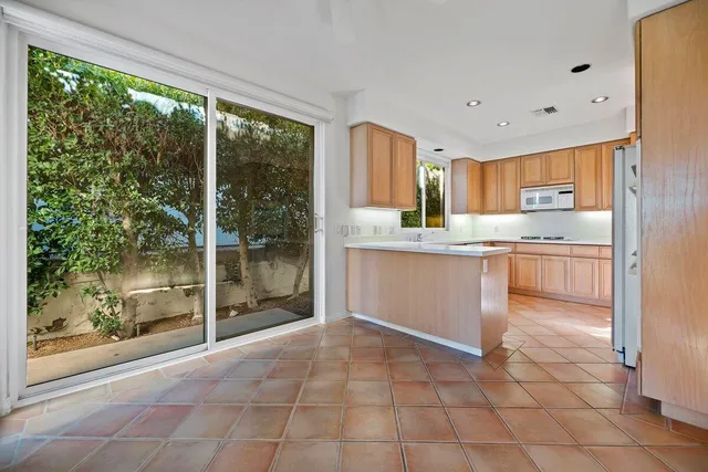 a kitchen with stainless steel appliances granite countertop a refrigerator and a sink