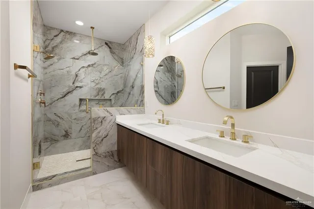 a bathroom with a double vanity sink mirror and shower