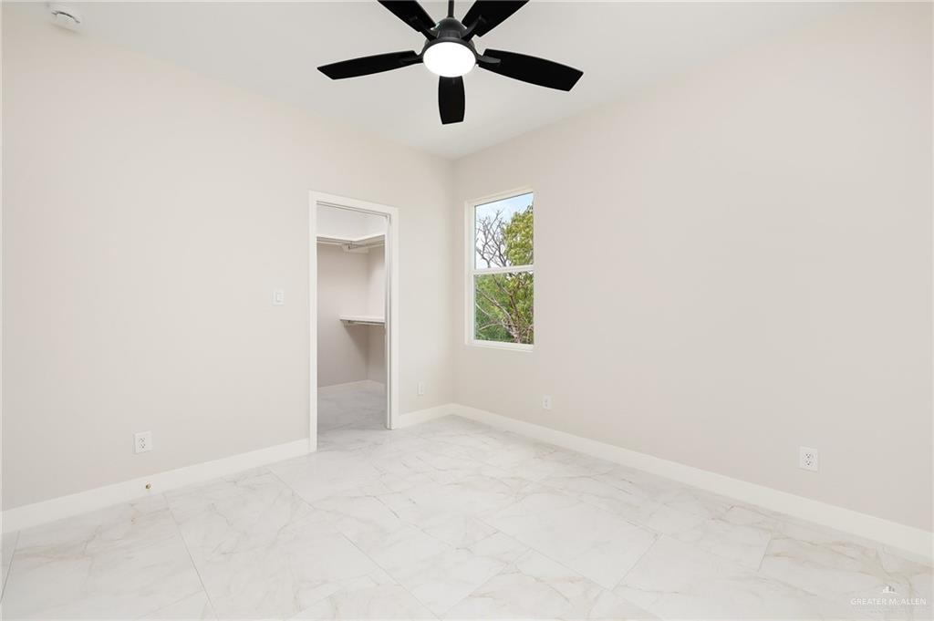 2705 East Solar Drive Mission, TX 78574 - Photo 13 of 16 an empty room with windows and fan