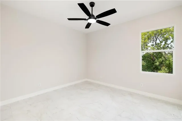 an empty room with a window and a fan