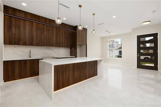 a kitchen with granite countertop a refrigerator and cabinets