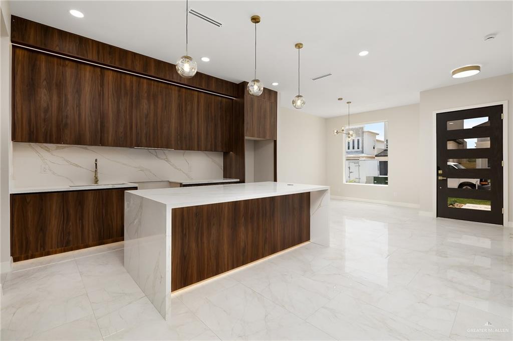 2705 East Solar Drive Mission, TX 78574 - Photo 4 of 16 a kitchen with granite countertop a refrigerator and cabinets