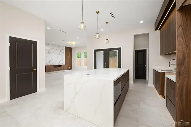 a large kitchen with a large counter top stainless steel appliances