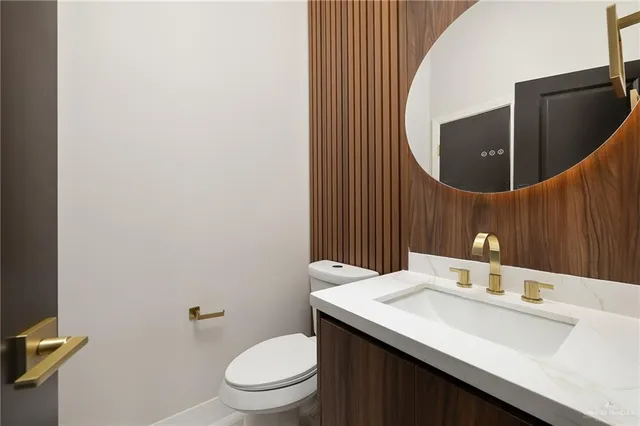 a bathroom with a sink a toilet and mirror