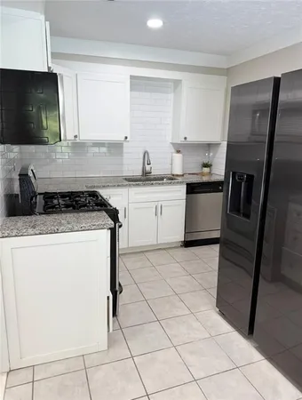 a kitchen with a sink a stove a microwave and cabinets