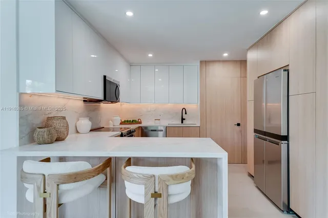 a kitchen with granite countertop a refrigerator and a stove top oven