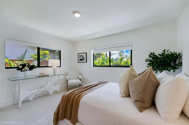 a bedroom with a bed and a potted plant