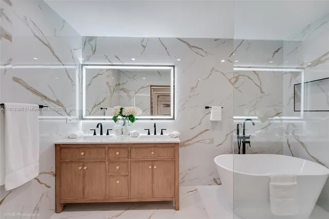 a spacious bathroom with a double vanity sink a mirror and a bathtub