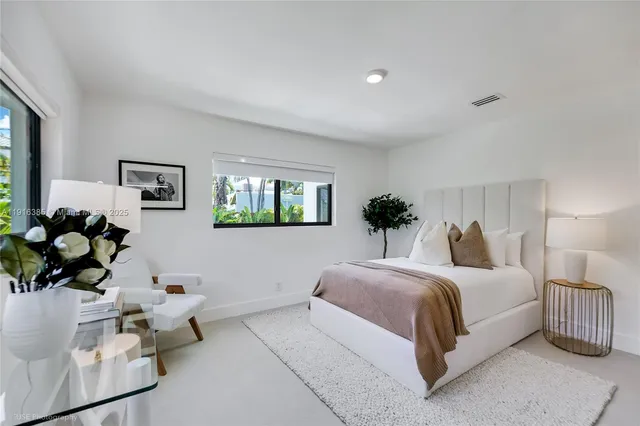 a bedroom with a bed mirror and window