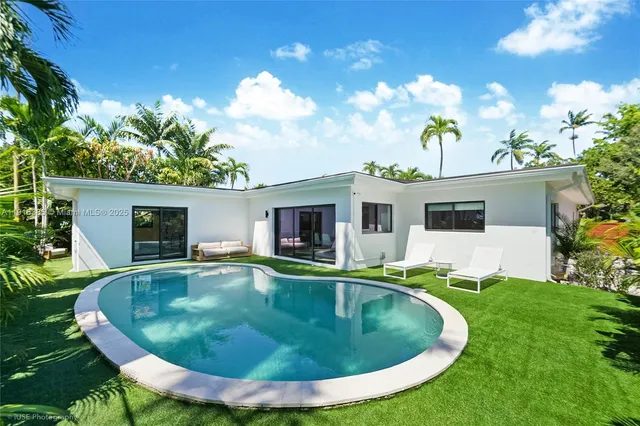 a view of a house with swimming pool and a yard