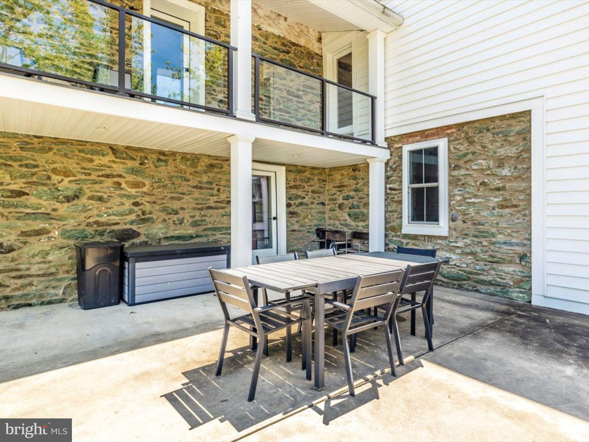 3501 Sams Creek Road New Windsor, MD 21776 - Photo 38 of 69 a view of a patio with table and chairs and wooden floor