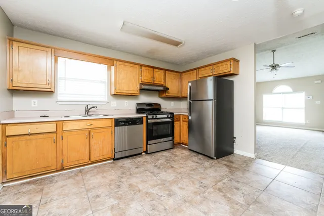 a kitchen with stainless steel appliances granite countertop a refrigerator and a sink