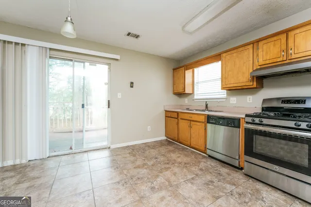a kitchen with stainless steel appliances granite countertop a stove a sink and a refrigerator
