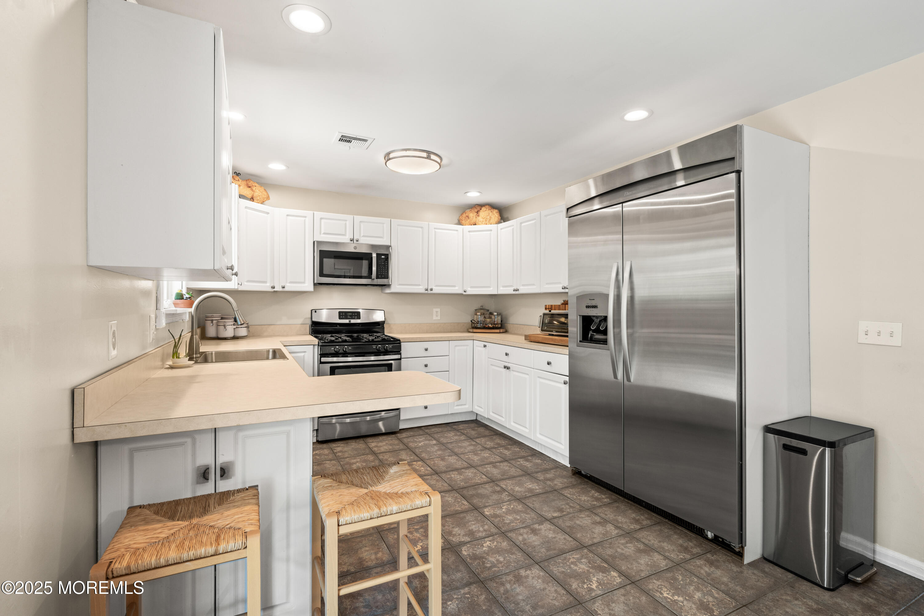 611 Drum Point Road Brick, NJ 08723 - Photo 9 of 35 a kitchen with granite countertop a refrigerator a sink a stove a microwave and island