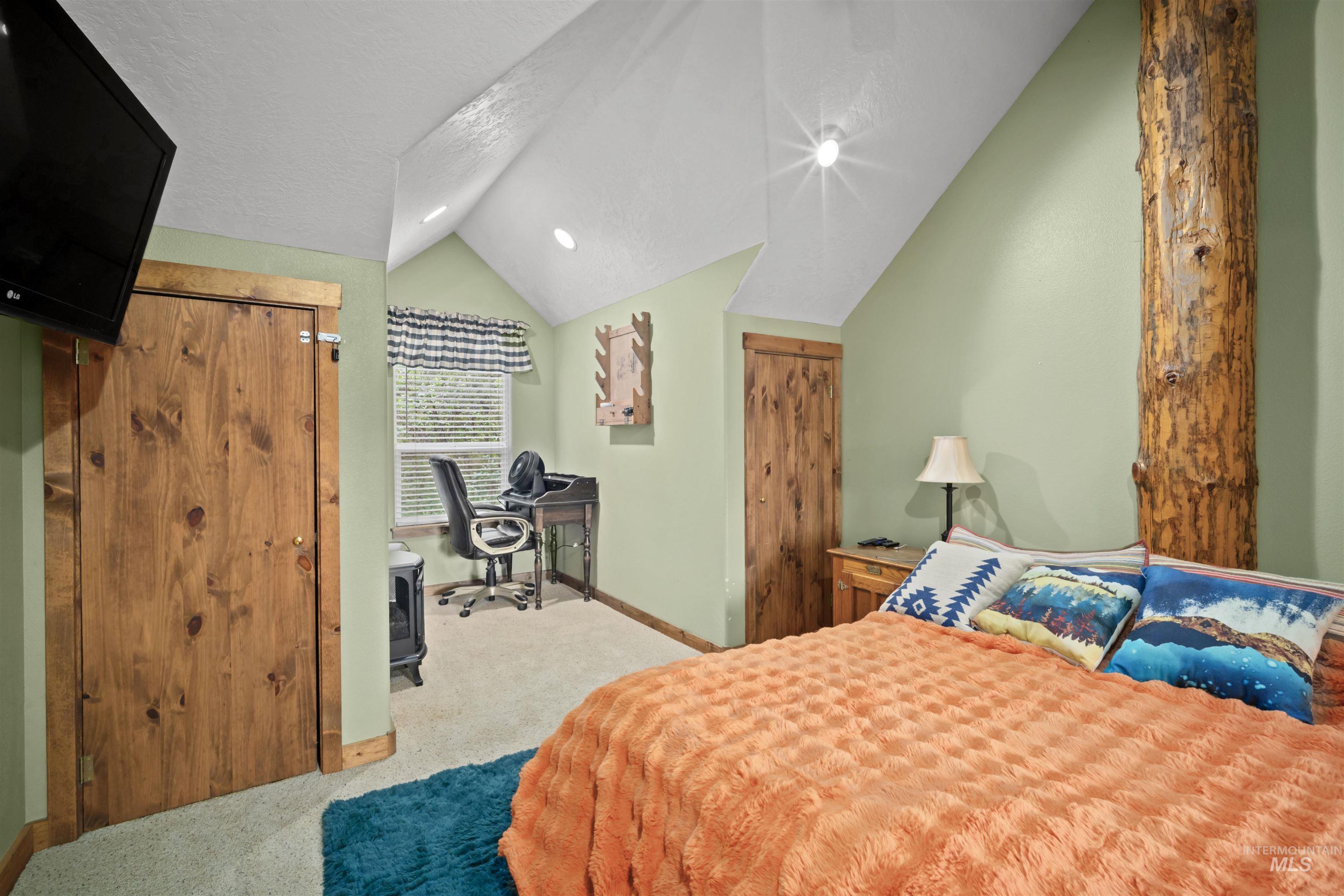 9 Deer Valley Road Garden Valley, ID 83622 - Photo 18 of 22 Vaulted ceiling room featuring a prominent exposed wood support column, light green painted walls, and natural wood doors