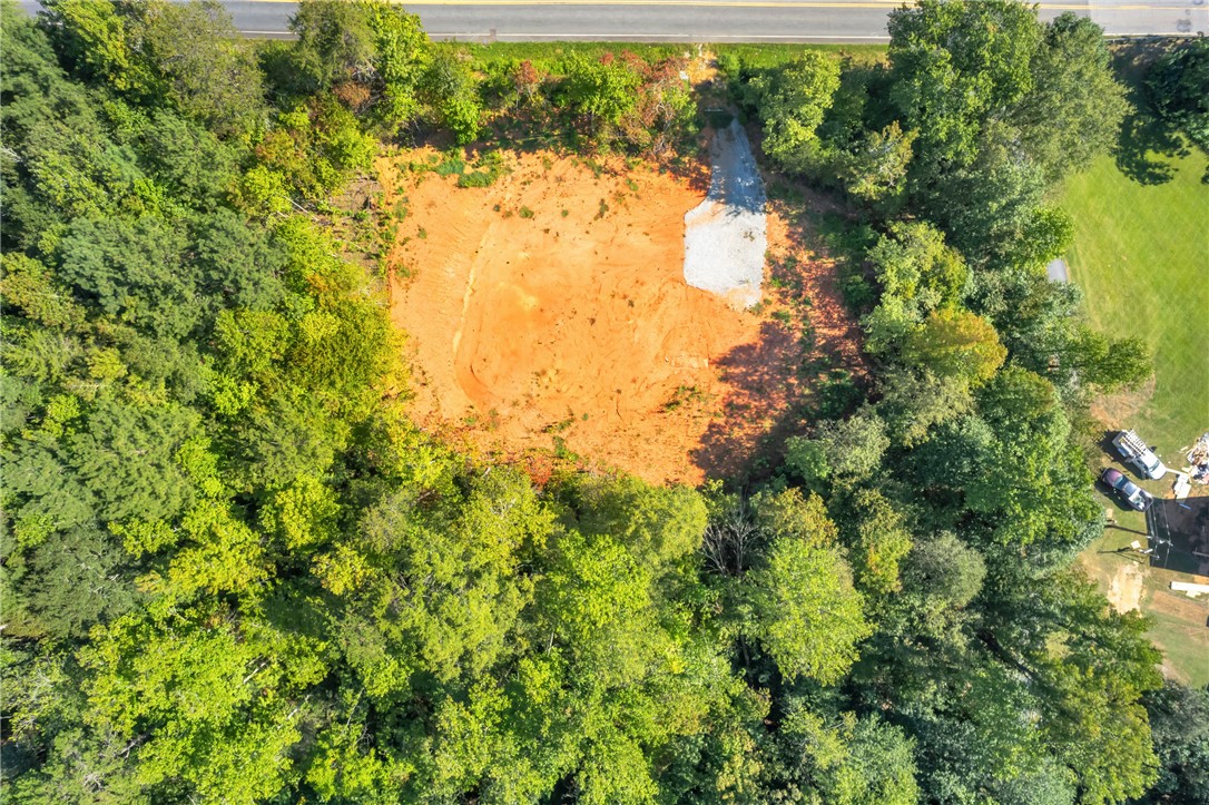 167 Cherokee Trail Easley, SC 29640 - Photo 17 of 18 A spacious, cleared lot bordered by lush woodland and a distant road.