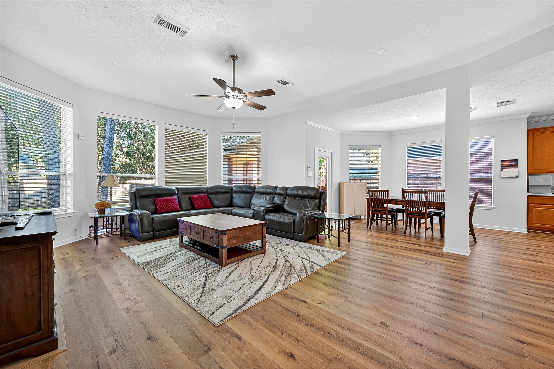 This spacious living area features abundant natural light from large windows. The open layout connects the heart of the home to the kitchen and  breakfast casual dining area.